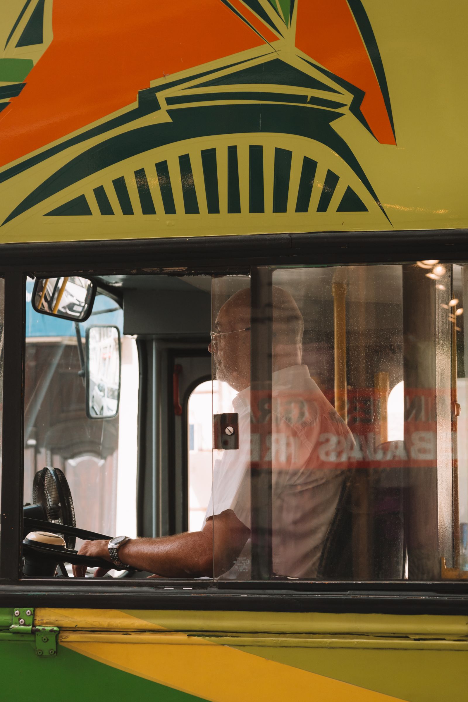 Kierowca autobusu miejskiego siedzący za kierownicą podczas kursu.